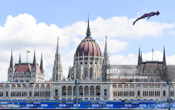 Cliff jumper Rhiannon Iffland from Australia trains against the backdrop of the Hungarian parliament before the preliminary rounds of the women's...