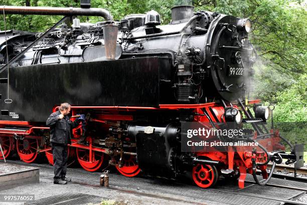 The engine driver cleans the steam engine 99 222 from 1931 with water at the station in Drei Annen Hohne, Germany, 24 July 2017. Although the job as...