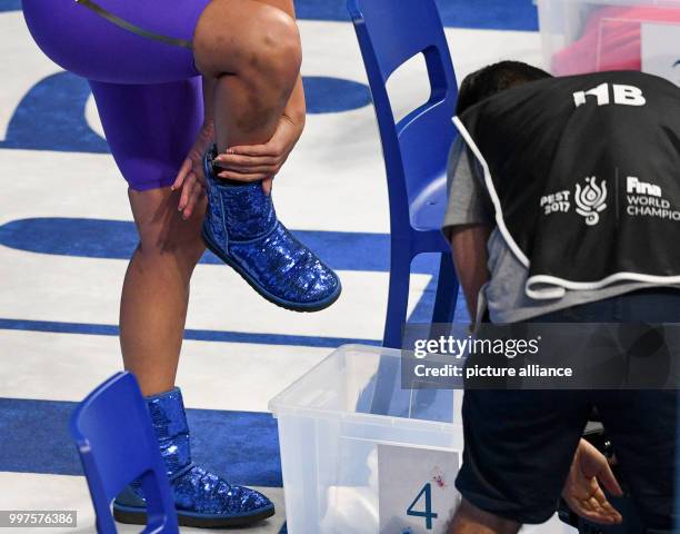 Kathleen Baker from the US takes off her blue 'Ugg-Boots' before the Women 200m Backstroke semifinale at the FINA World Championships in Budapest,...