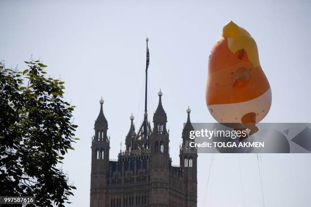 Giant balloon depicting US President Donald Trump as an orange baby floats next to The Victoria Tower of the Palace of Westminster during a...