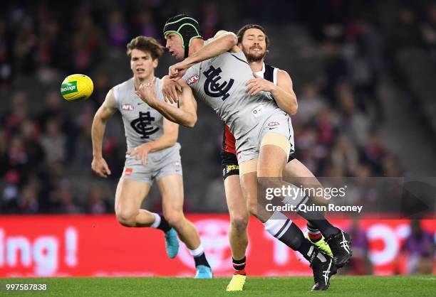 Matthew Kreuzer of the Blues handballs whilst being tackled by Jack Steven of the Saints during the round 17 AFL match between the St Kilda Saints...