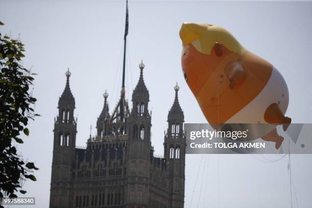 Giant balloon depicting US President Donald Trump as an orange baby floats next to The Victoria Tower of the Palace of Westminster during a...
