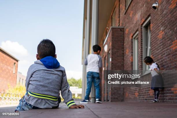 July 2018, Netherlands, Ter Apel: Three children, living as refugees at a reception centre, photographed at the central reception centre for asylum...