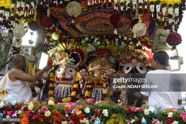 Indian devotees from the International Society for Krishna Consciousness perform rituals in a chariot carrying a deity during the Sri Krishna Rath...