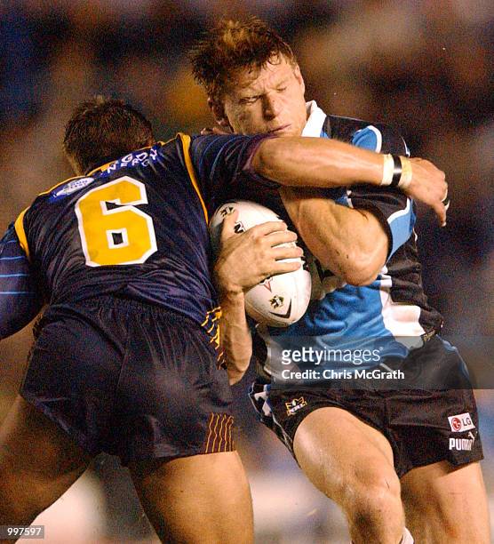 Nathan Long of the Sharks is tackled by Ashley Harrison of the Broncos in action during the NRL First Qualifying Final between the Cronulla Sharks...