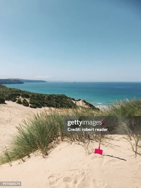 pink child’s spade in sand dunes overlooking beach - e reader - fotografias e filmes do acervo