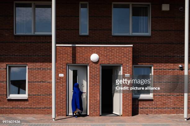 July 2018, Netherlands, Ter Apel: A veiled woman leaving acoomodation at the central reception centre for asylum seekers 'VluchtelingenWerk...
