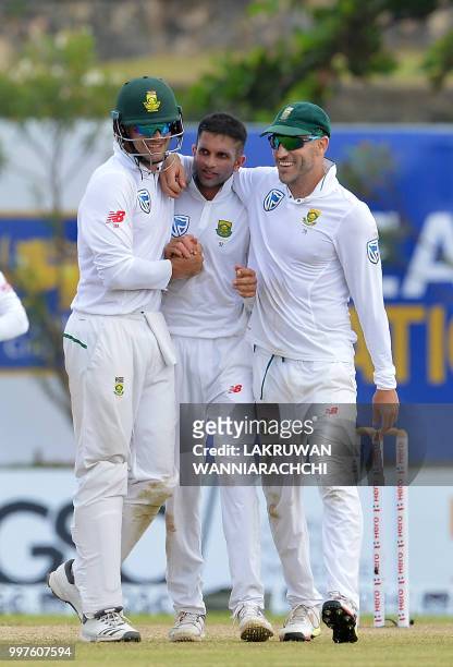 South Africa's Keshav Maharaj celebrates with his teammates Faf du PLessis and Dean Elgar after he dismissed Sri Lanka's Dhananjaya de Silva during...