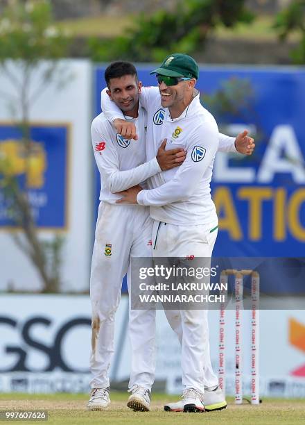 South Africa's Keshav Maharaj celebrates with his teammate Faf du PLessis after he dismissed Sri Lanka's Dhananjaya de Silva during the second day of...