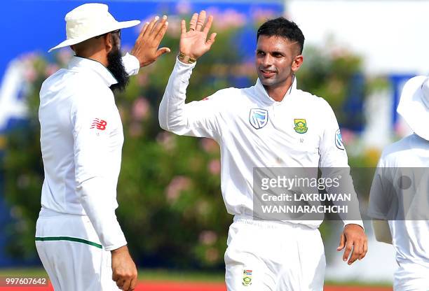 South Africa's Keshav Maharaj celebrates with his teammate Hashim Amla after he dismissed Sri Lanka's Danushka Gunathilaka during the second day of...