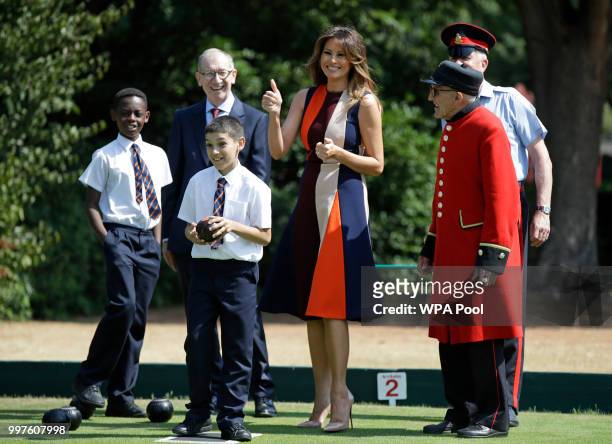 First Lady Melania Trump gestures as she plays bowls with Philip May, the husband of British Prime Minister Theresa May during a visit to British...