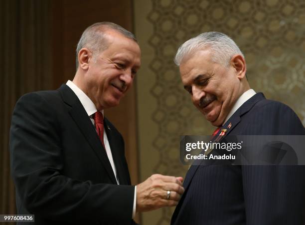 Turkish President Recep Tayyip Erdogan gives the medal to honor Turkish Grand National Assembly Speaker Binali Yildirim with Order of Merit for his...