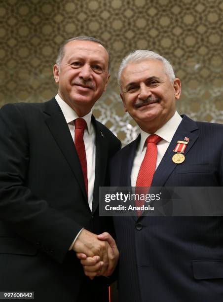 Turkish President Recep Tayyip Erdogan gives the medal to honor Turkish Grand National Assembly Speaker Binali Yildirim with Order of Merit for his...