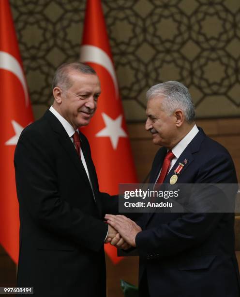 Turkish President Recep Tayyip Erdogan gives the medal to honor Turkish Grand National Assembly Speaker Binali Yildirim with Order of Merit for his...