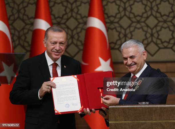 Turkish Grand National Assembly Speaker Binali Yildirim presents Turkish Prime Ministry's seal to Turkish President Recep Tayyip Erdogan after...