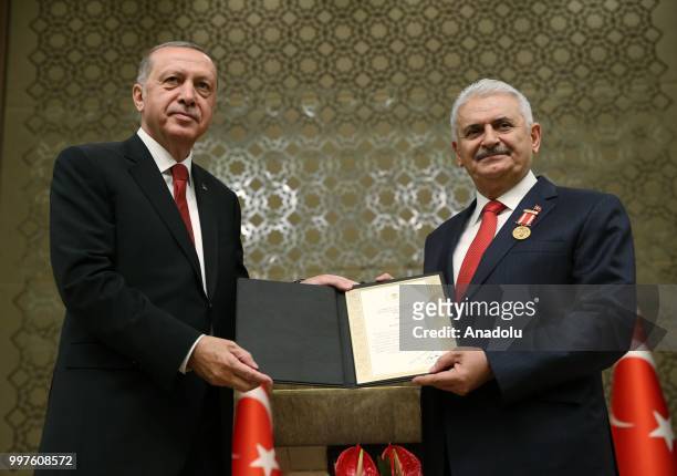Turkish President Recep Tayyip Erdogan gives the certificate to honor Turkish Grand National Assembly Speaker Binali Yildirim with Order of Merit for...