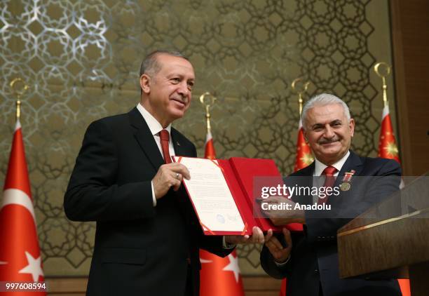 Turkish Grand National Assembly Speaker Binali Yildirim presents Turkish Prime Ministry's seal to Turkish President Recep Tayyip Erdogan after...