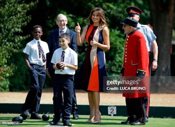 First Lady Melania Trump plays bowls accompanied by the British prime minister's husband Philip May and a Chelsea Pensioner as she visits the Royal...
