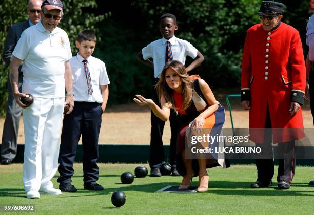 First Lady Melania Trump plays bowls accompanied by a Chelsea Pensioner as she visits the Royal Chelsea Hospital in London on July 13, 2018 on the...