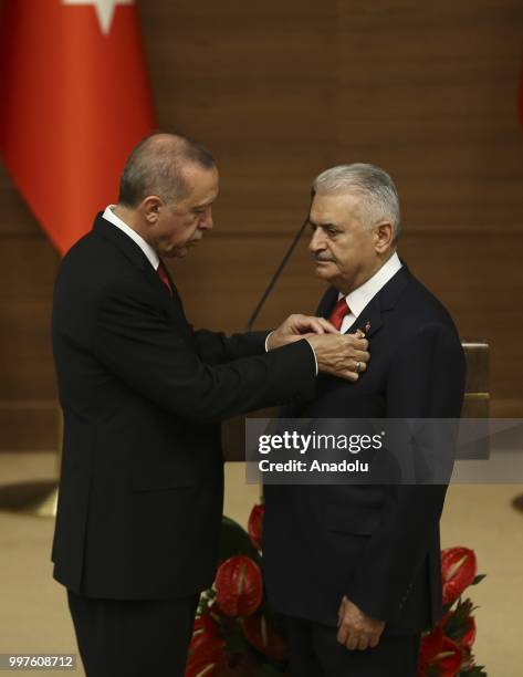 Turkish President Recep Tayyip Erdogan gives the medal to honor Turkish Grand National Assembly Speaker Binali Yildirim with Order of Merit for his...