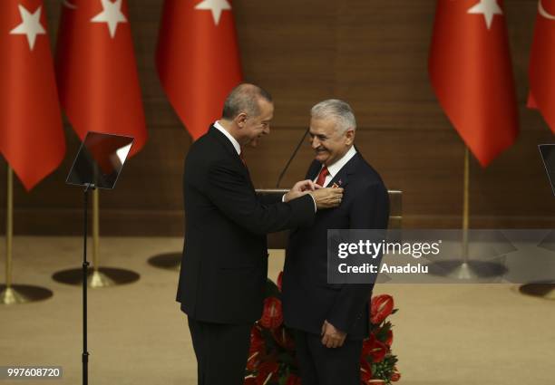 Turkish President Recep Tayyip Erdogan gives the medal to honor Turkish Grand National Assembly Speaker Binali Yildirim with Order of Merit for his...