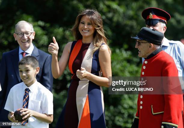 First Lady Melania Trump gives a thumbs up as she plays bowls with school children accompanied by the British prime minister's husband Philip May and...