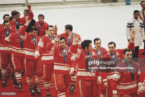 View of the gold medal winning Soviet Union ice hockey team pictured together walking off the medal podium after finishing in first place in the...