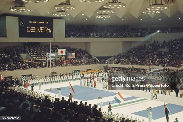 View of flag bearers and athletes from competing countries standing together and participating in the closing ceremony of the 1972 Winter Olympics...
