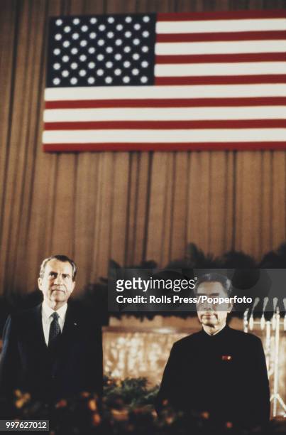 President of the United States, Richard Nixon pictured on left standing in front of a large American flag with Zhou Enlai , 1st Premier of the...