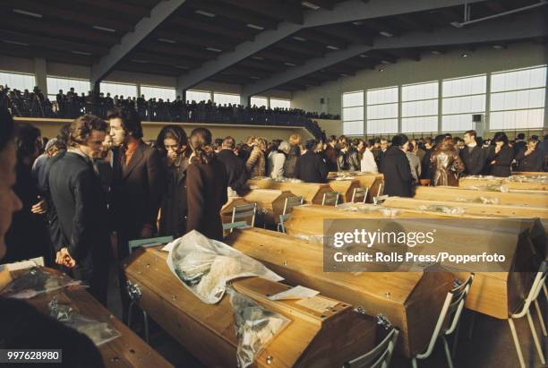 View of relatives paying their respects to coffins containing the bodies of 142 young fire victims in a school gymnasium in the town of...