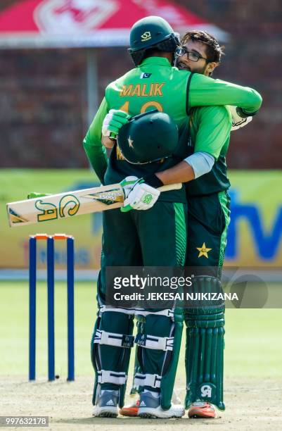 Pakistan's batsman Imam-Ul-Haq is embraced by teammate Shoaib Malik as he celebrates after scoring a century during the first one day international...