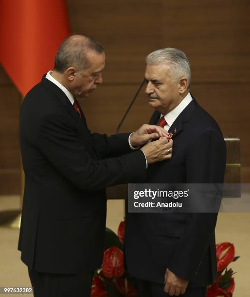 Turkish President Recep Tayyip Erdogan gives the medal to honor Turkish Grand National Assembly Speaker Binali Yildirim with Order of Merit for his...