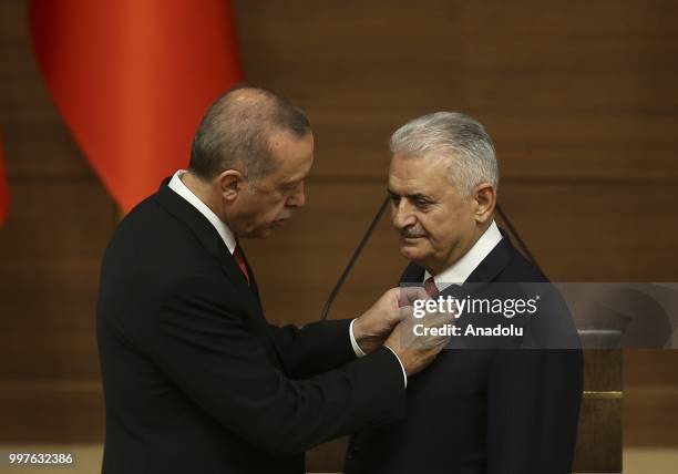 Turkish President Recep Tayyip Erdogan gives the medal to honor Turkish Grand National Assembly Speaker Binali Yildirim with Order of Merit for his...