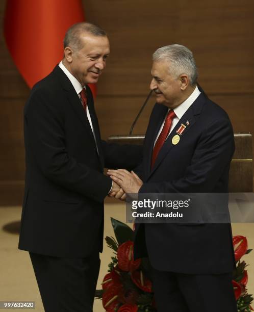 Turkish President Recep Tayyip Erdogan gives the medal to honor Turkish Grand National Assembly Speaker Binali Yildirim with Order of Merit for his...