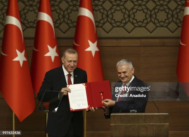 Turkish Grand National Assembly Speaker Binali Yildirim presents Turkish Prime Ministry's seal to Turkish President Recep Tayyip Erdogan after...