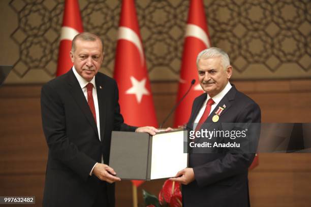 Turkish President Recep Tayyip Erdogan gives the certificate to honor Turkish Grand National Assembly Speaker Binali Yildirim with Order of Merit for...