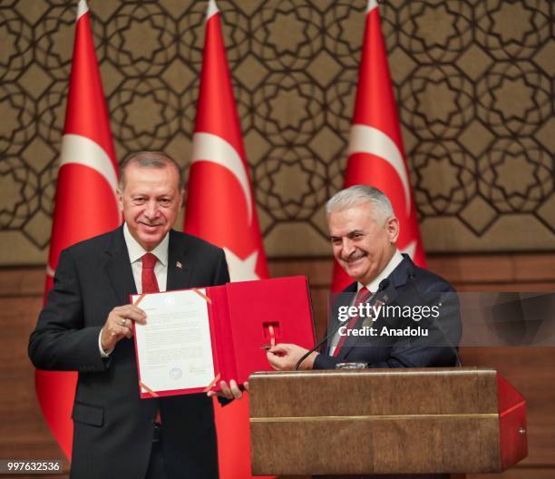 Turkish Grand National Assembly Speaker Binali Yildirim presents Turkish Prime Ministry's seal to Turkish President Recep Tayyip Erdogan after...