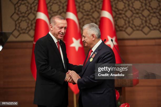 Turkish President Recep Tayyip Erdogan gives the medal to honor Turkish Grand National Assembly Speaker Binali Yildirim with Order of Merit for his...