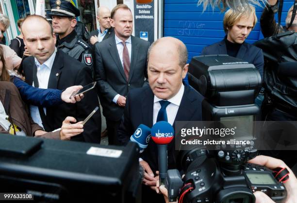 Hamburg's first mayor Olaf Scholz speaks in front of the supermarket where a person was killed and six furhter people were injured by a knife...