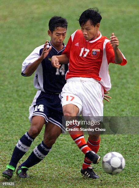 Aung Tun Naing of Myanmar is checked by Masrezwan Masturi of Singapore in a Group A match at the MPPJ Stadium, Petaling Jaya, Malaysia during the...