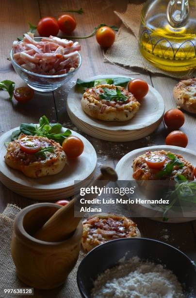 rustic table with mini pizzas of bacon - mini pizza stock pictures, royalty-free photos & images