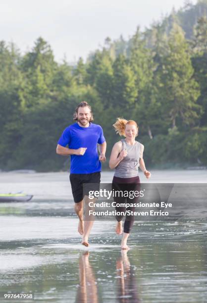 couple jogging together at beach - dark haired man gray shirt with wine stock pictures, royalty-free photos & images