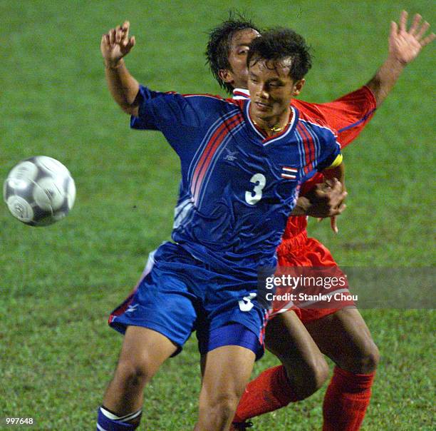 Preratat Phoruandee of Thailand is checked by Phengta Phounsamay of Laos in a Group A match held at the MPPJ Stadium, Petaling Jaya, Malaysia during...