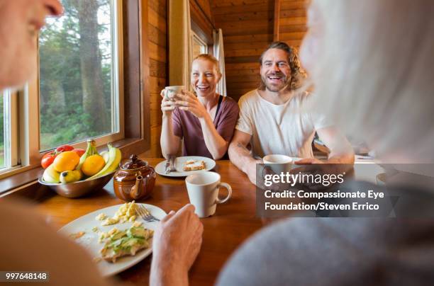 family enjoying breakfast in cabin - family with one child mother bonding family adult daughter focus on background leisure stock-fotos und bilder