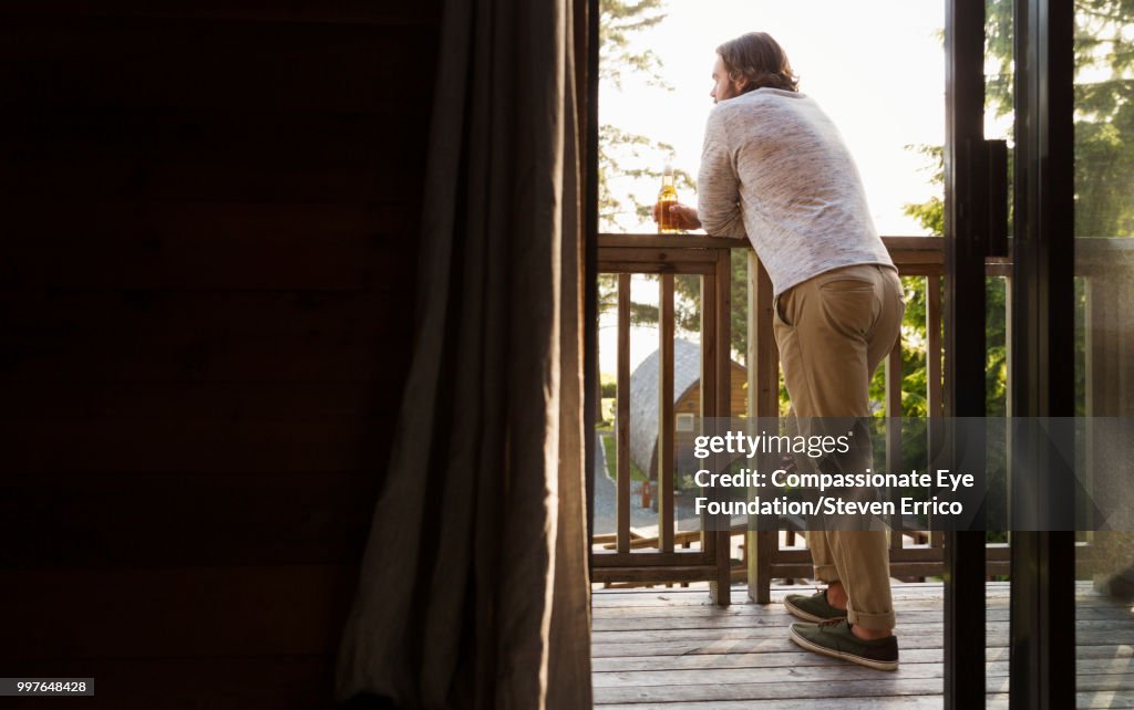 Man leaning on balcony looking at view