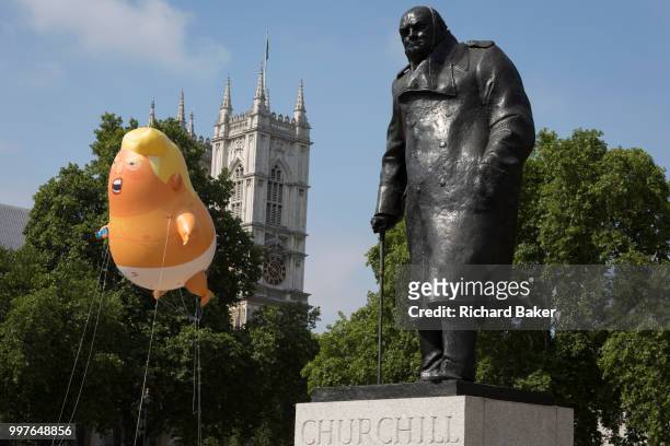 The inflatable balloon called Baby Trump flies above the statue of wartime Brish Prime Minister Winston Churchill in Parliament Square, Westminster,...