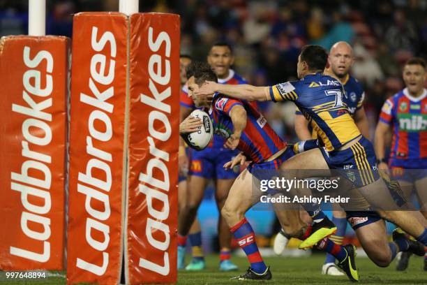 Mitchell Pearce of the Knights runs in to score a try during the round 18 NRL match between the Newcastle Knights and the Parramatta Eels at McDonald...