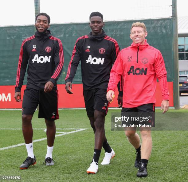 Ro-Shaun Williams, Axel Tuanzebe and Fitness Coach Gary Walker of Manchester United in action during a first team training session at Aon Training...