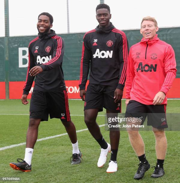 Ro-Shaun Williams, Axel Tuanzebe and Fitness Coach Gary Walker of Manchester United in action during a first team training session at Aon Training...