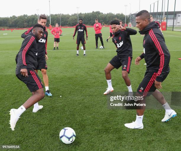 Timothy Fosu-Mensah, Demetri Mitchell and Antonio Valencia of Manchester United in action during a first team training session at Aon Training...